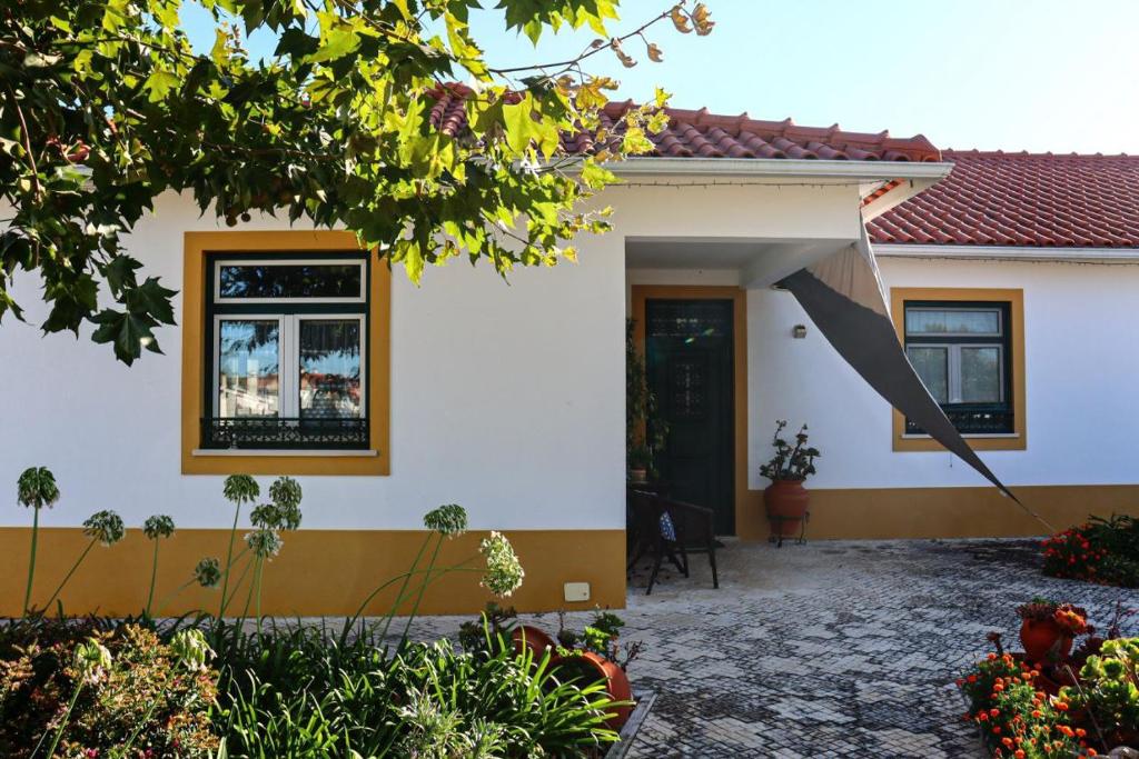 ein Haus mit einem Regenschirm davor in der Unterkunft Casa Robusto in Salvaterra de Magos