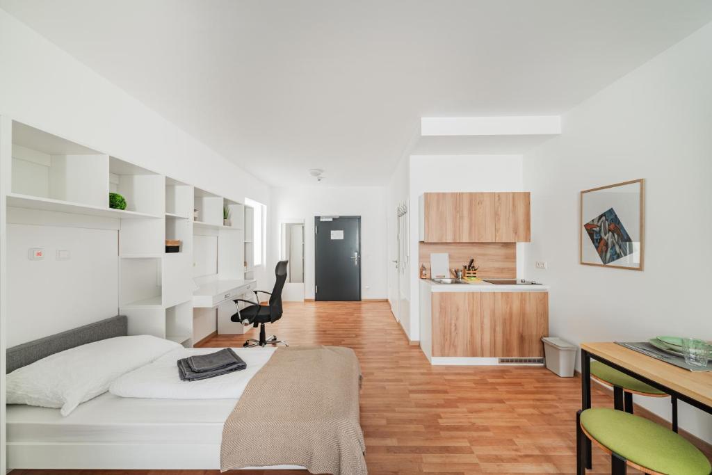 a bedroom with a bed and a desk with a chair at Central City Suits in Wiener Neustadt