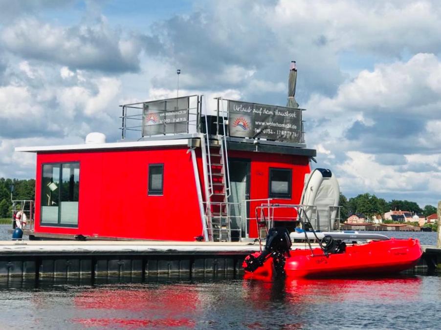 a red boat is docked at a dock at Schwimmendes Ferienhaus "Enola" Ihr Riverloft auf der Havel in Fürstenberg