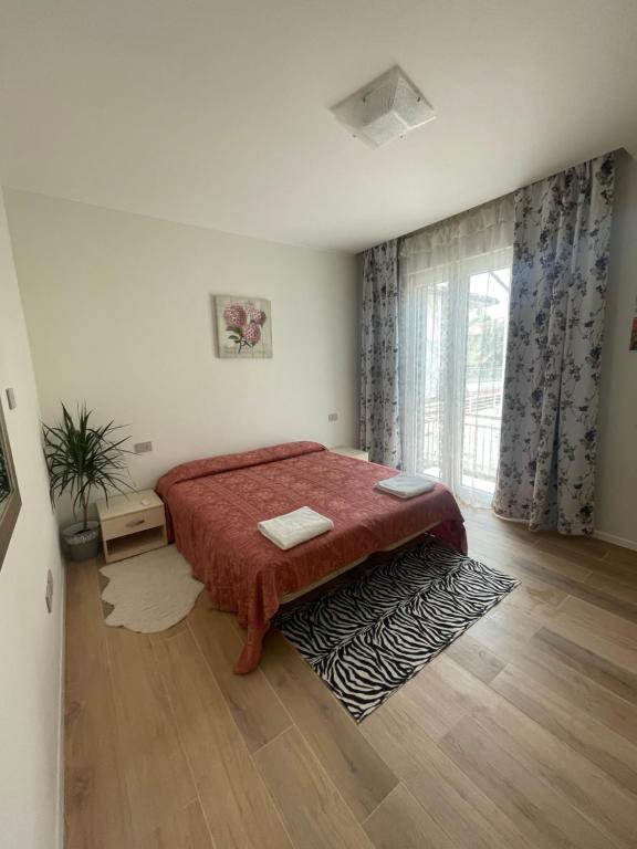una camera con un letto e una grande finestra di Appartamento Miramare a Rimini