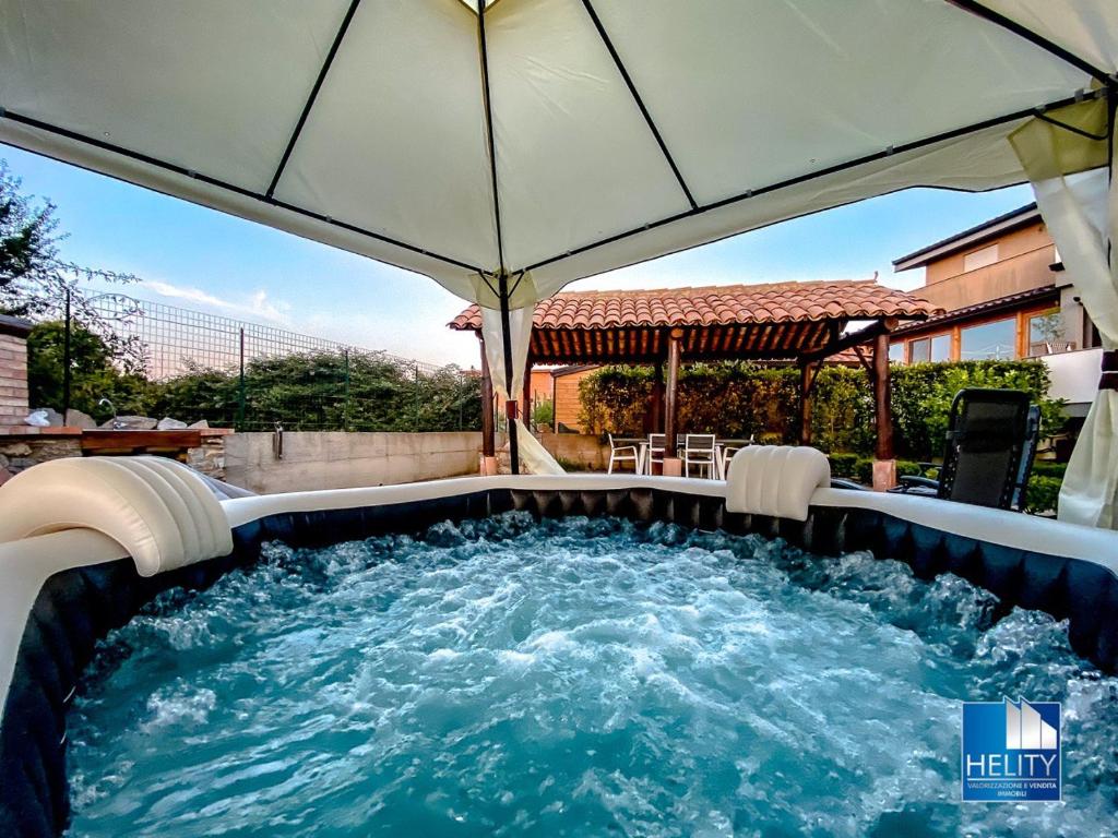 a hot tub in a backyard with an umbrella at * [Stalettì] *La casa sul mare* in Stalettì