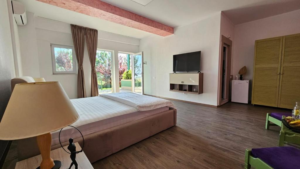 ein Schlafzimmer mit einem großen Bett und einem TV in der Unterkunft BC Aprilia in Corbu