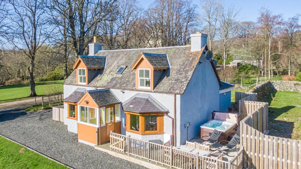 une petite maison entourée d'une clôture dans l'établissement Gardener’s Cottage with Hot Tub, à Blairgowrie