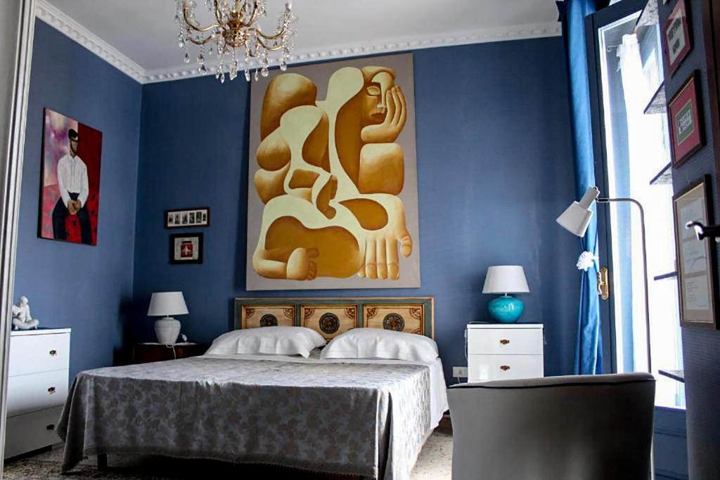 una camera blu con un letto e un dipinto sul muro di B&B RESIDENZA DUCALE a Taviano