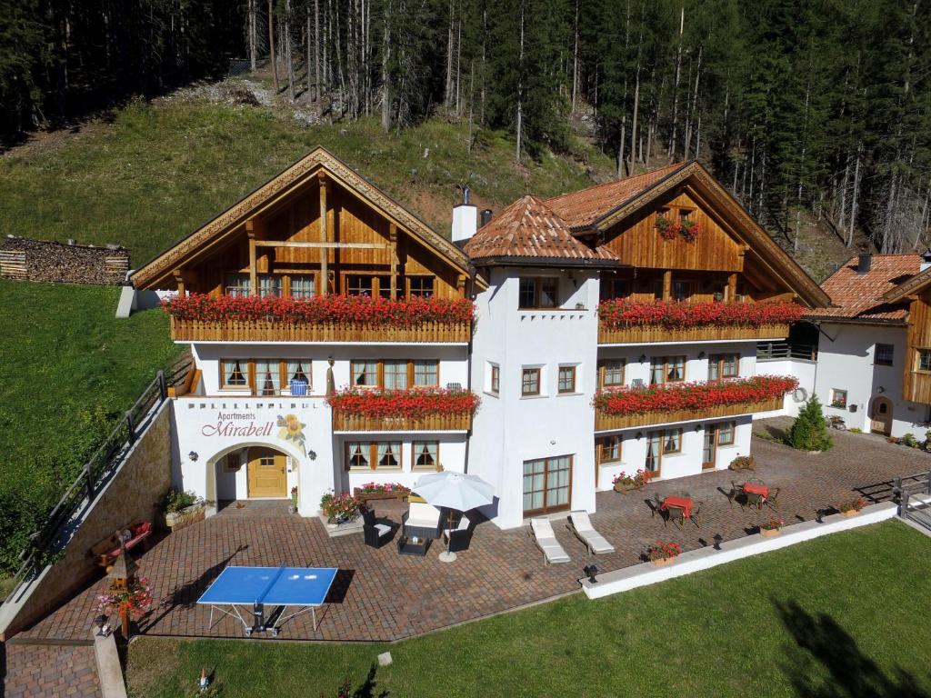 an aerial view of a large white building with a patio at Apartments Mirabell in Livinallongo del Col di Lana
