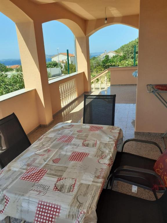 a table and chairs in a room with a view at Apartmani Drage in Drage