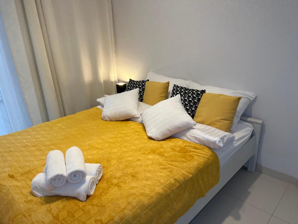 a yellow bed with two towels on top of it at I&M Apartments Sikorskiego Wrocław in Wrocław