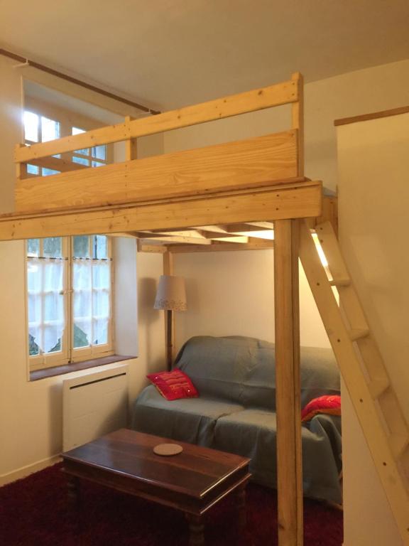 - un lit en mezzanine dans un salon avec un canapé dans l'établissement Sympa au calme sur le jardin, à Carcassonne