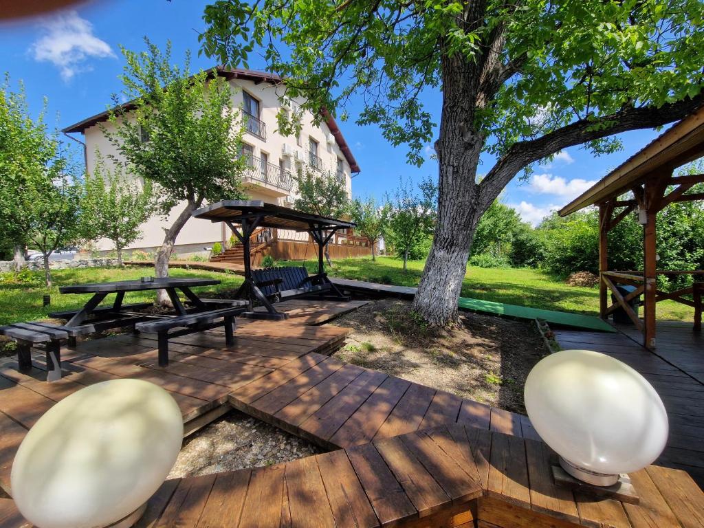 a picnic area with benches and a tree at Pensiunea Bella Vista in Turda