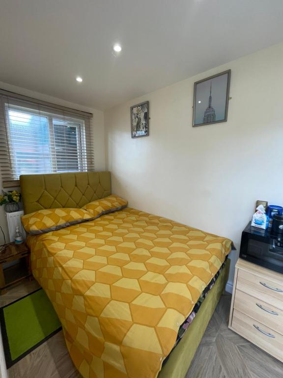 a bedroom with a yellow bed in a room at Mitcham Let 11 in Mitcham