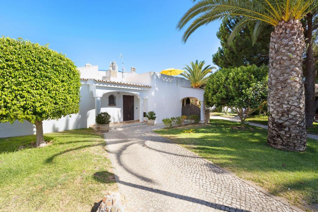 a white house with a palm tree and a driveway at Casa Palmeira in Armação de Pêra
