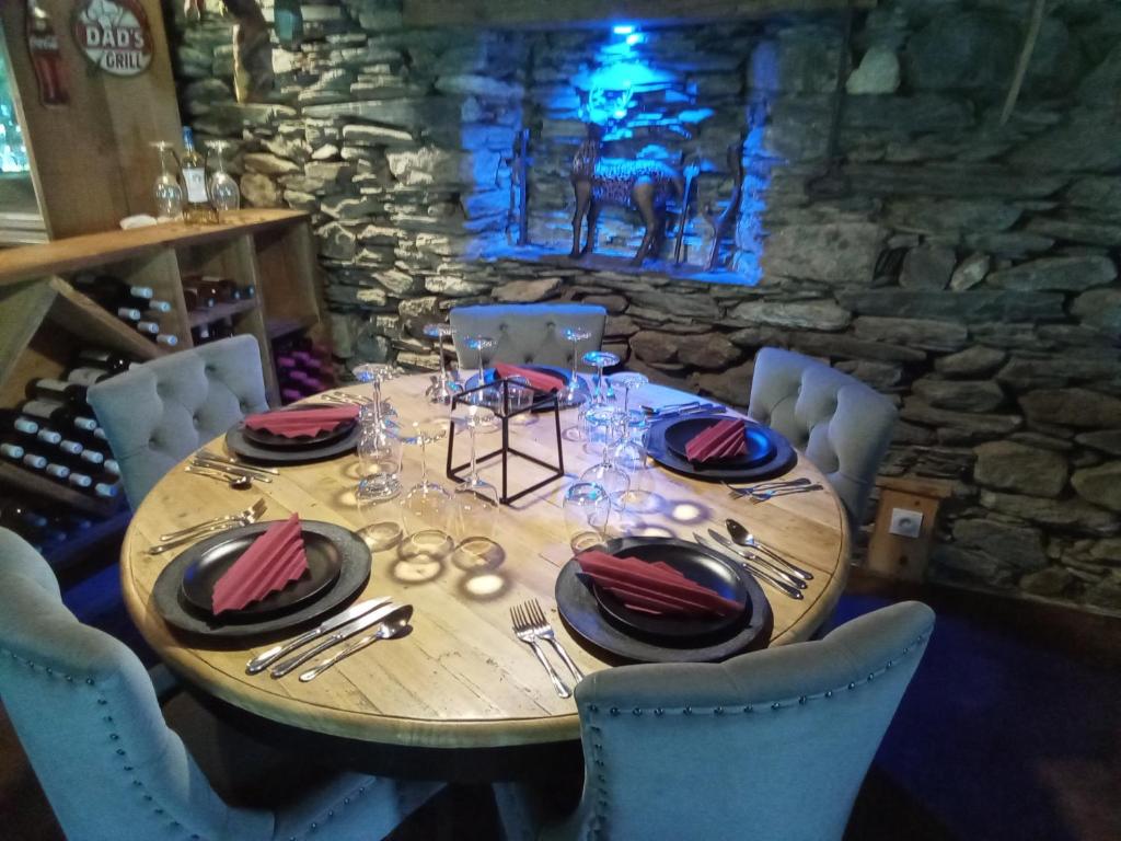 una mesa de madera con platos y servilletas. en L' Auberge du château, en Génos