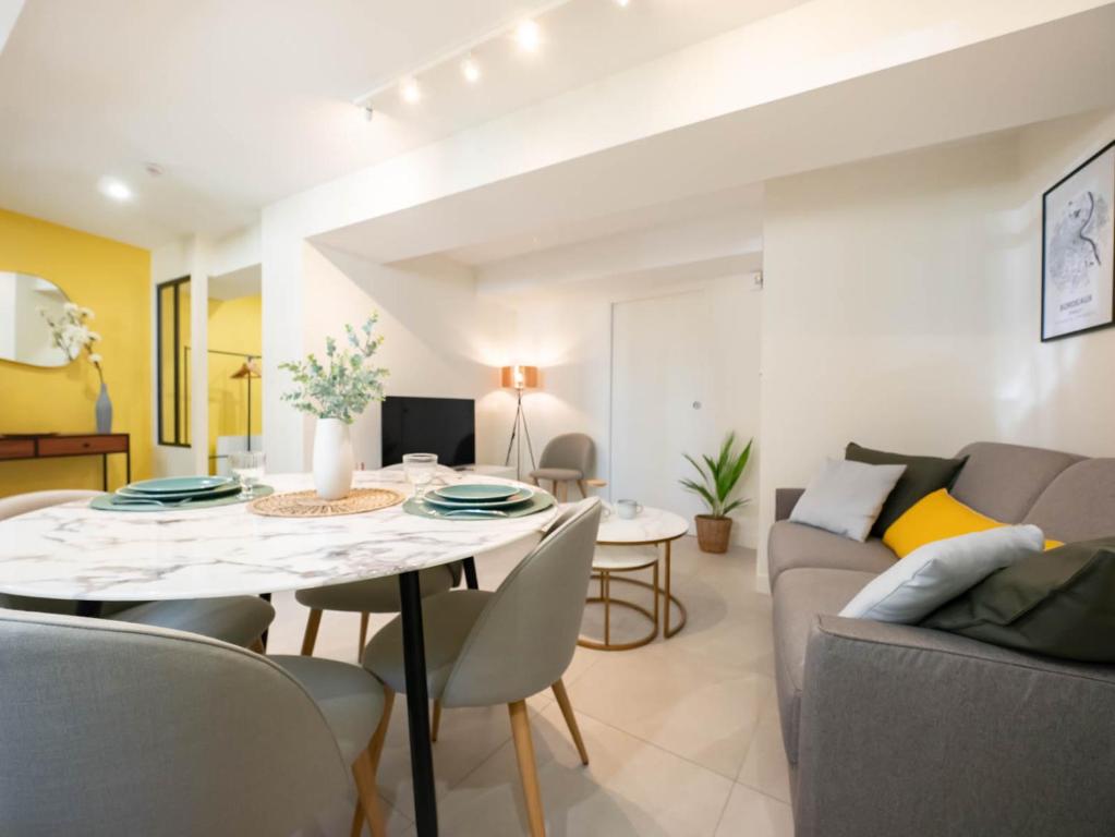 une salle à manger et un salon avec une table et des chaises dans l'établissement Le petit olivier en coeur de ville + Parking incl., à Montpellier