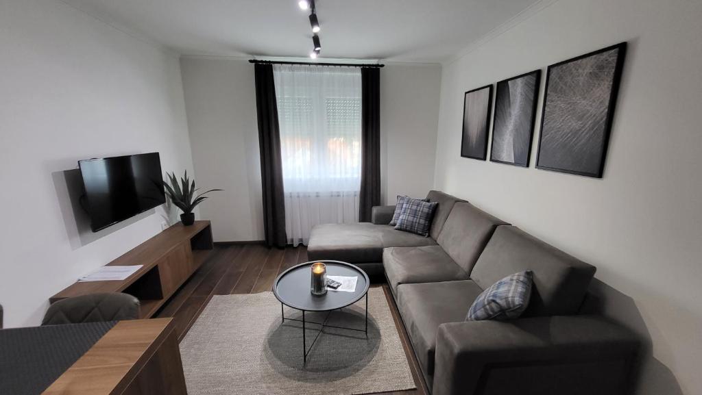 een woonkamer met een bank en een tafel bij Apartments Spring in Čačak