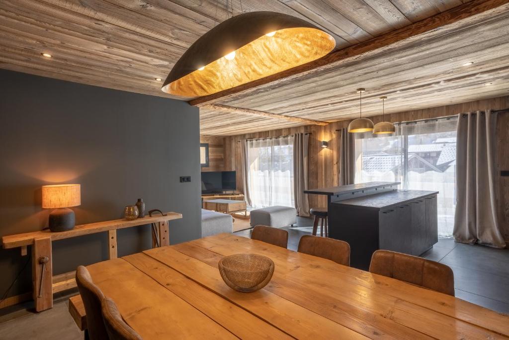 uma sala de jantar com uma mesa de madeira e uma cozinha em Appartement Les Myrtilles - pied des pistes - 10 personnes em Les Deux Alpes