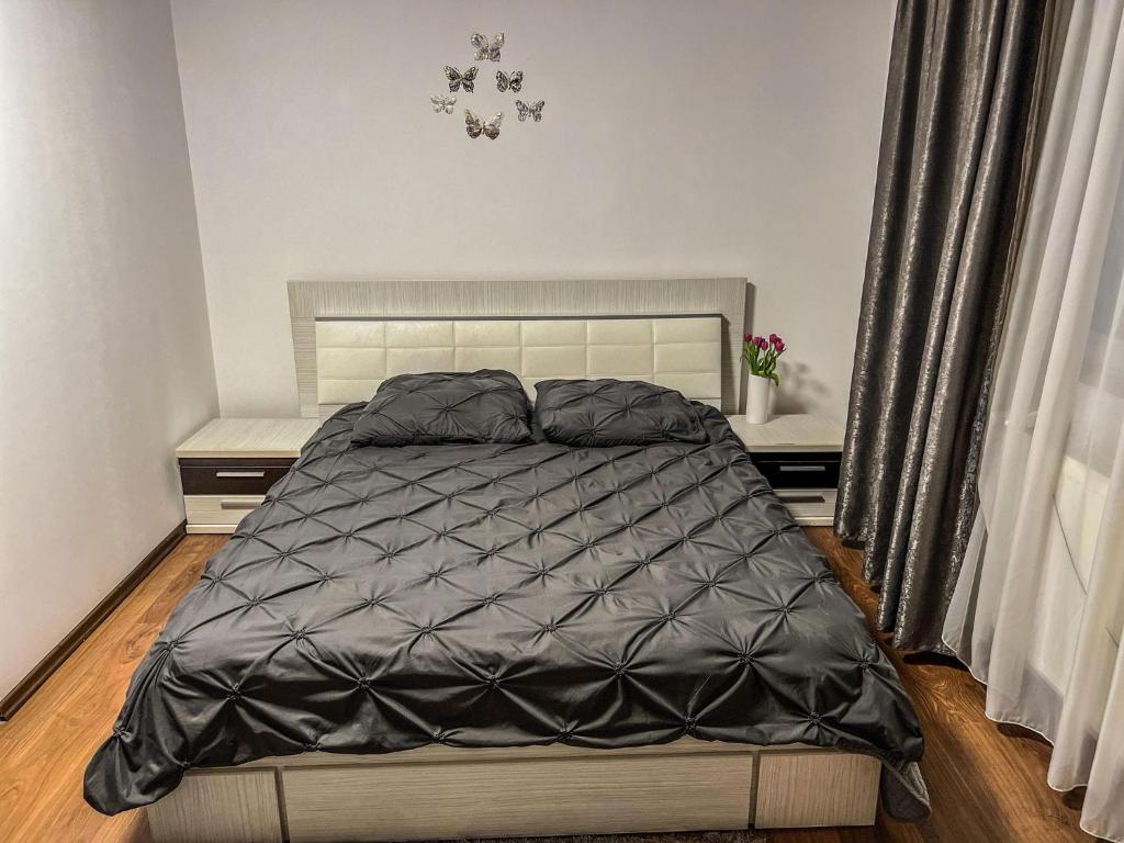 a bedroom with a bed with a black comforter at Pensiunea Brezu in Sighetu Marmaţiei