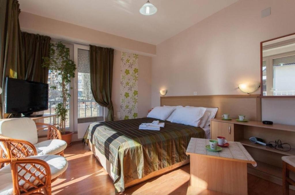 a hotel room with a bed and a tv at De Lux Apartments Kosta in Ohrid