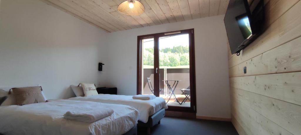 Les Hôpitaux-NeufsにあるRésidence Le Sommetのベッドルーム1室(ベッド2台、大きな窓付)