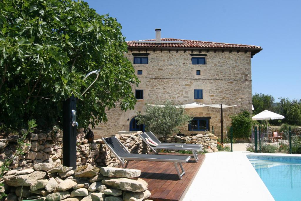 een huis met een zwembad en een gebouw bij Hotel Rural Casa La Sonrisa in Hedeso