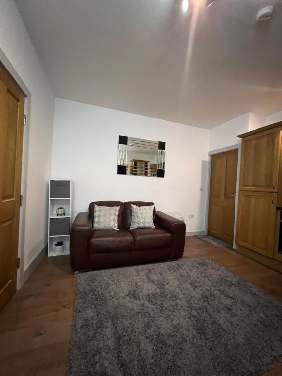 sala de estar con sofá marrón y alfombra en Flat 3 Rylands Street en Warrington