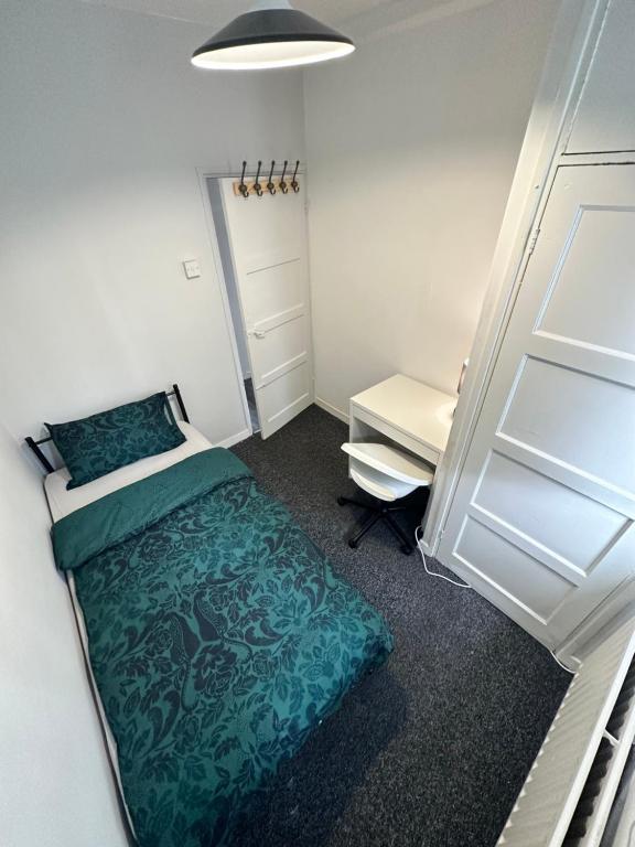 a small bedroom with a bed and a desk at Shoreditch Rooms R2 in London