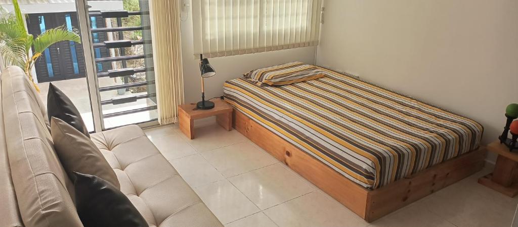 een bed in een kamer met een bank en een raam bij Donde Memo in Santa Rosa de Cabal