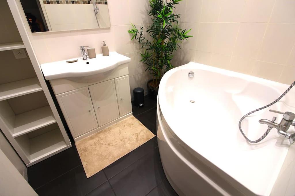 a bathroom with a sink and a tub and a toilet at Le Central Parc - T2-Spacieux-Clim-Wifi in Marseille