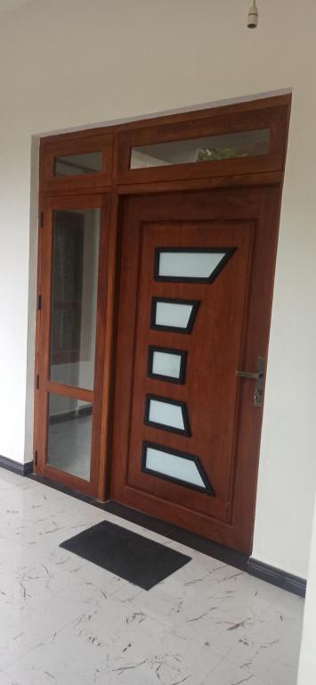 una puerta de madera con una ventana en la pared en Gagana Vila, en Kandy