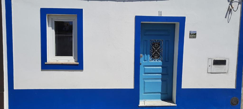 a blue door and a window on a building at Casa Esmar in Odemira