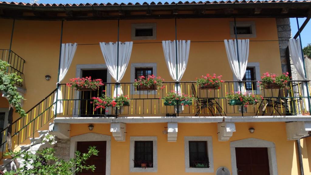 Casa vacanze - alloggio agrituristico Col في Monrupino: مبنى به نباتات الفخار على الشرفات