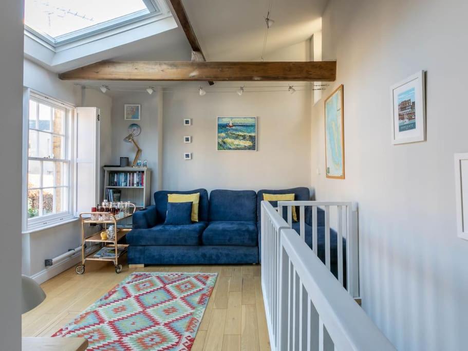 a living room with a blue couch and a window at The Coach House - Unique split level property in Kent
