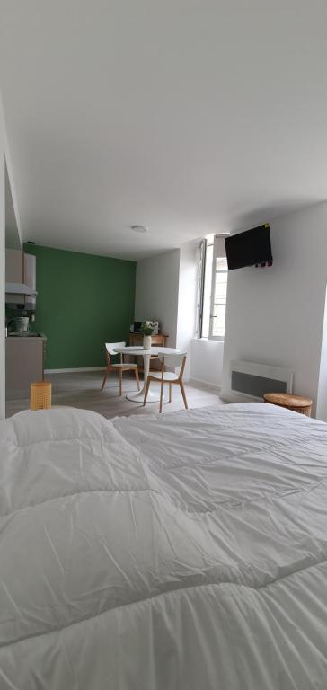 ein Schlafzimmer mit einem Bett, einem Tisch und Stühlen in der Unterkunft Agréable studio in Bourgueil