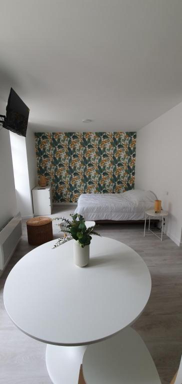 sala de estar con mesa blanca y cama en Agréable studio en Bourgueil