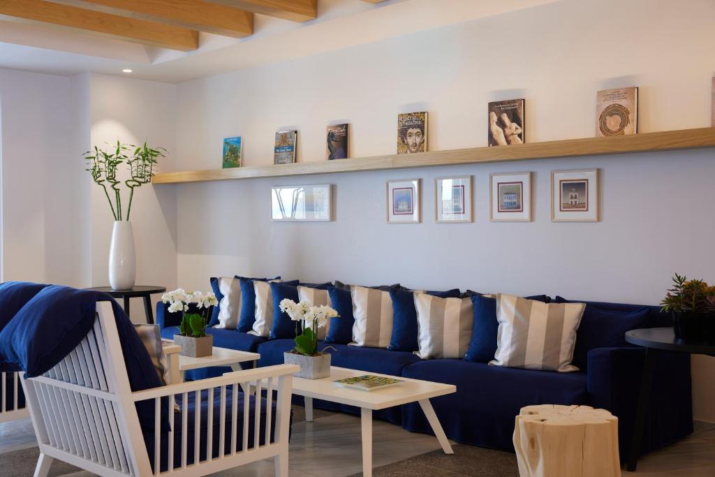 a living room with a blue couch and a table at Summer Senses Luxury Resort in Logaras