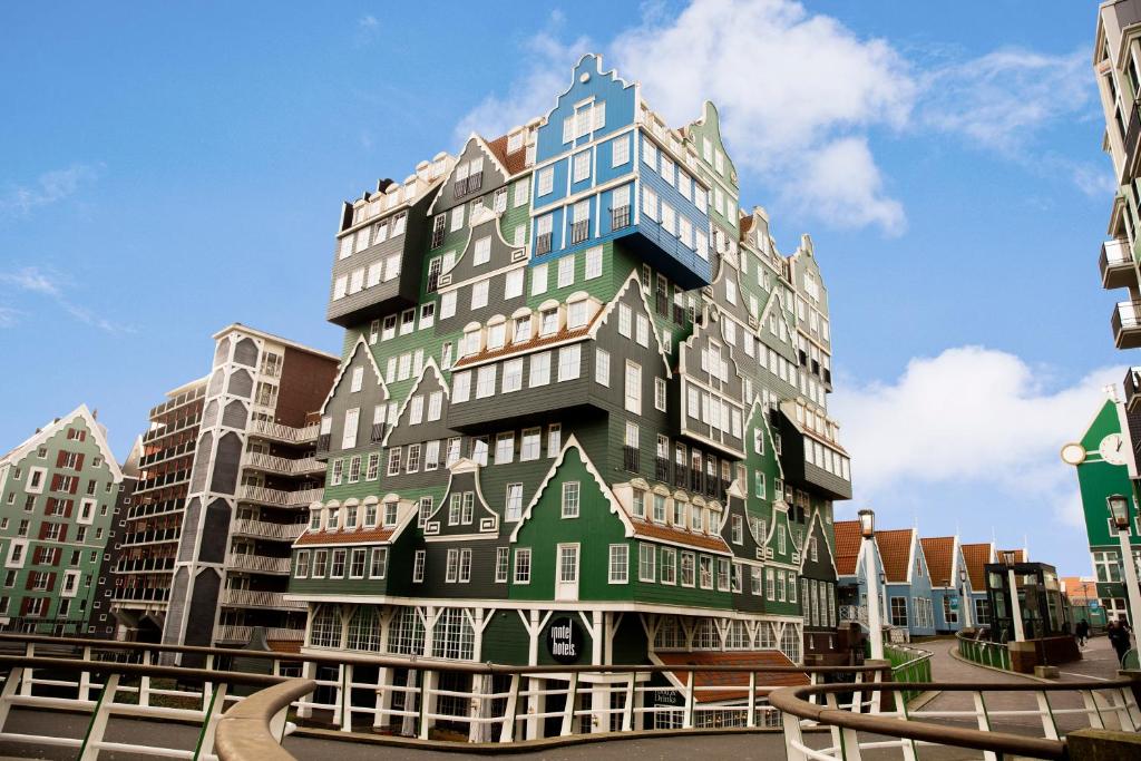 un grand bâtiment vert et blanc dans une ville dans l'établissement Inntel Hotels Amsterdam Zaandam, à Zaandam