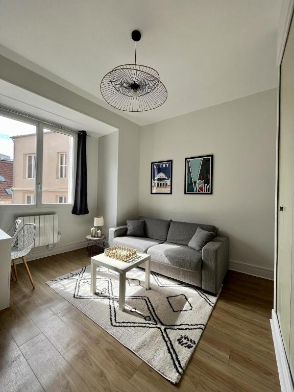 a living room with a couch and a table at Appartement Vichy - Hyper Centre in Vichy