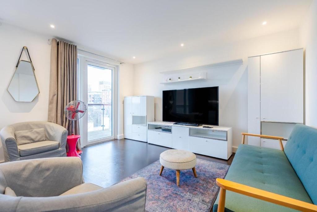 a living room with a couch and a tv at Superb 2 bed 2 baths Apartment in Woolwich
