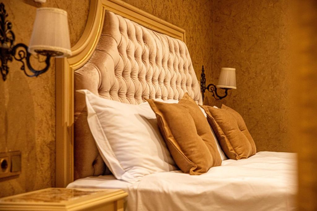 een bed met witte lakens en kussens in een kamer bij Luxury Apartment Rich 2 in Velingrad