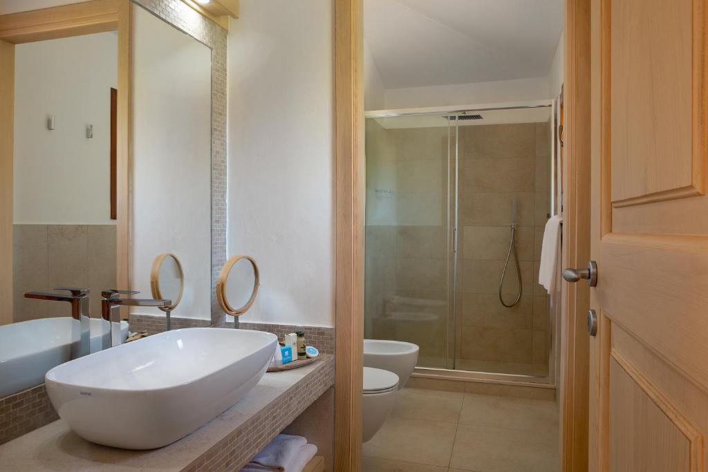 a bathroom with a large white sink and a shower at Hotel Capriccioli in Porto Cervo