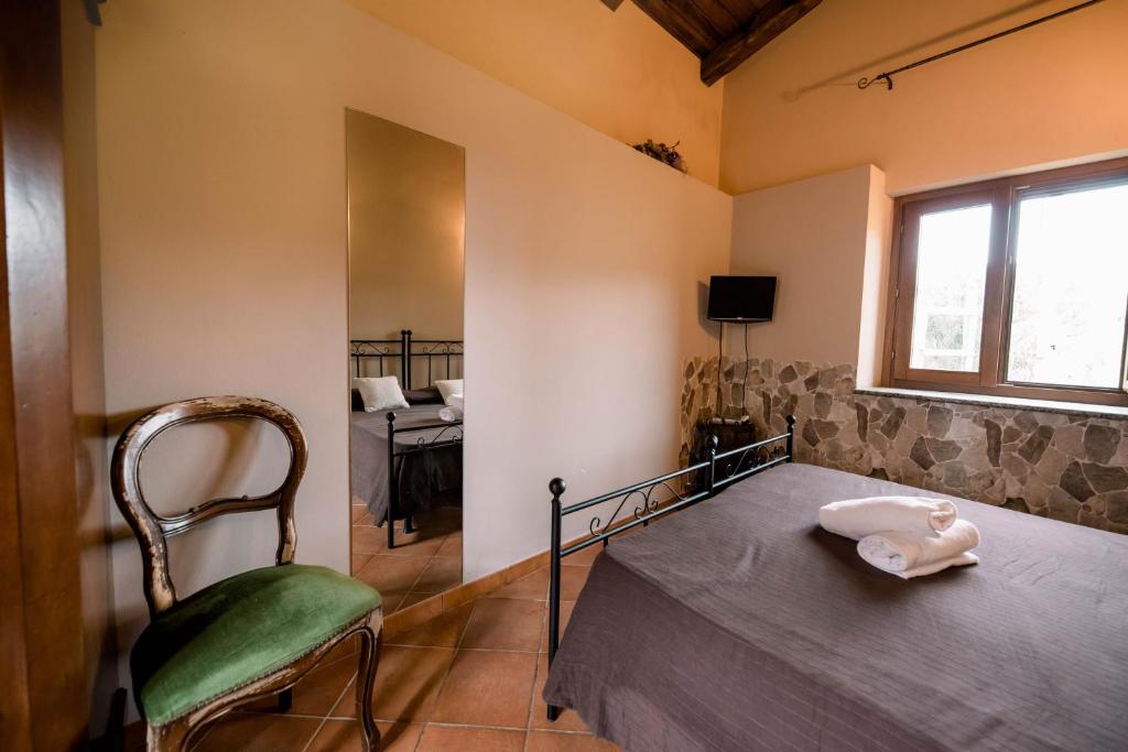a bedroom with a bed and a chair and a window at Agriturismo La Sena in Santa Caterina Dello Ionio Marina