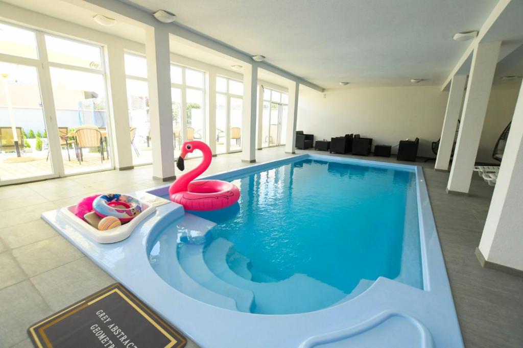 a swimming pool with a swan and a swan float at Olymp Apartmani in Kladovo