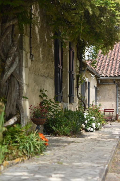 un bâtiment avec des fleurs devant un bâtiment dans l'établissement Un jardin et trois maisons, à Brux