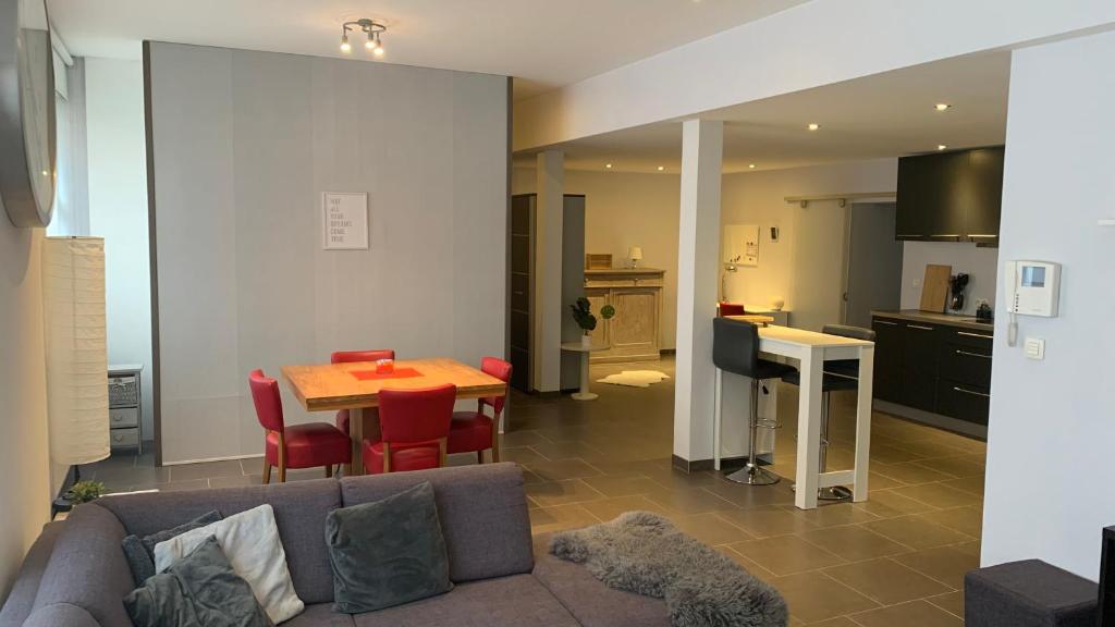 een woonkamer met een bank en een tafel en een keuken bij Ruime studio in Deurne in Antwerpen
