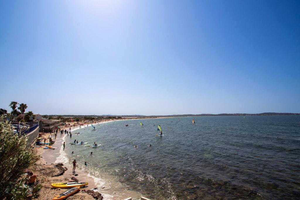 um grupo de pessoas na água em uma praia em Bright pearl with garden near the sea em Hyères