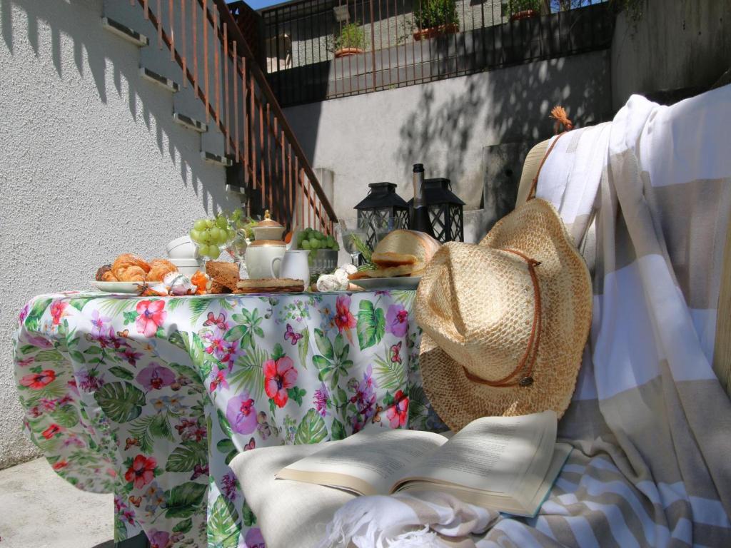 Una mesa con sombrero y una cesta de comida. en La casa di Beppin, en Sassello