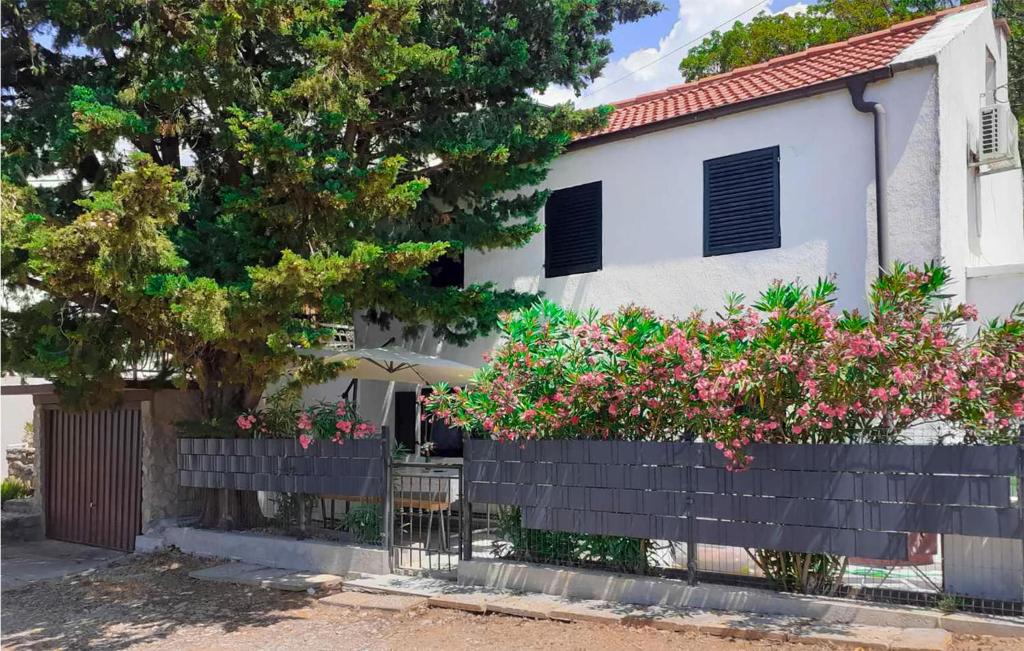 ein weißes Haus mit rosa Blumen davor in der Unterkunft Nice Home In Stinica With Kitchen in Stinica