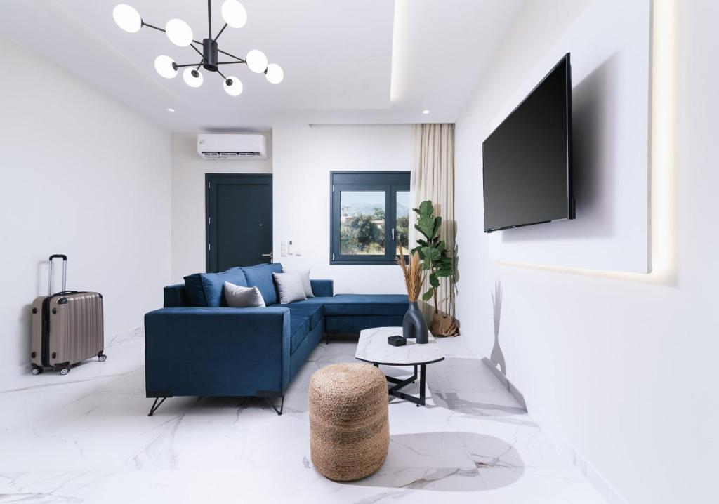 a living room with a blue couch and a tv at Arbona Apartment Ι in Vóroi