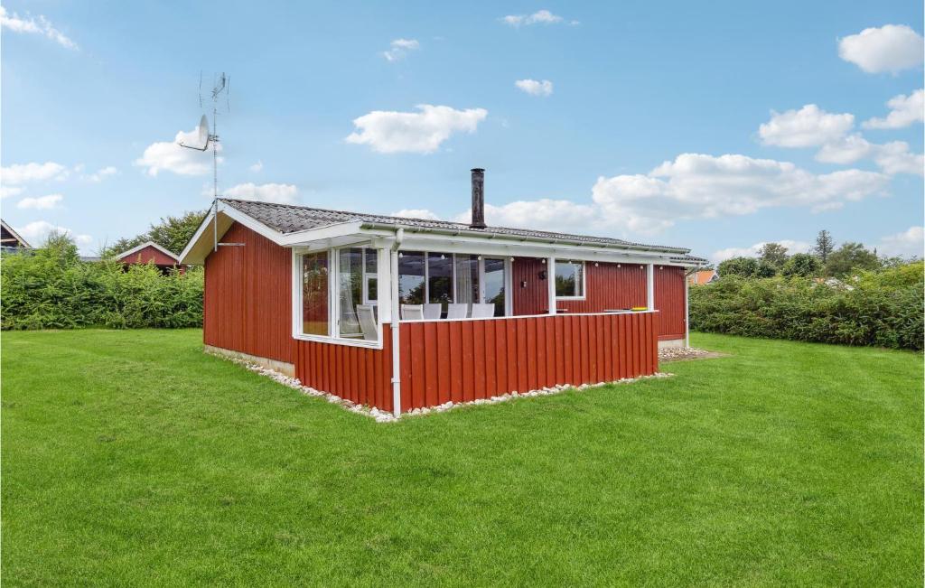 HaslevgårdeにあるAmazing Home In Hadsund With 3 Bedroomsの緑の芝生の赤い家