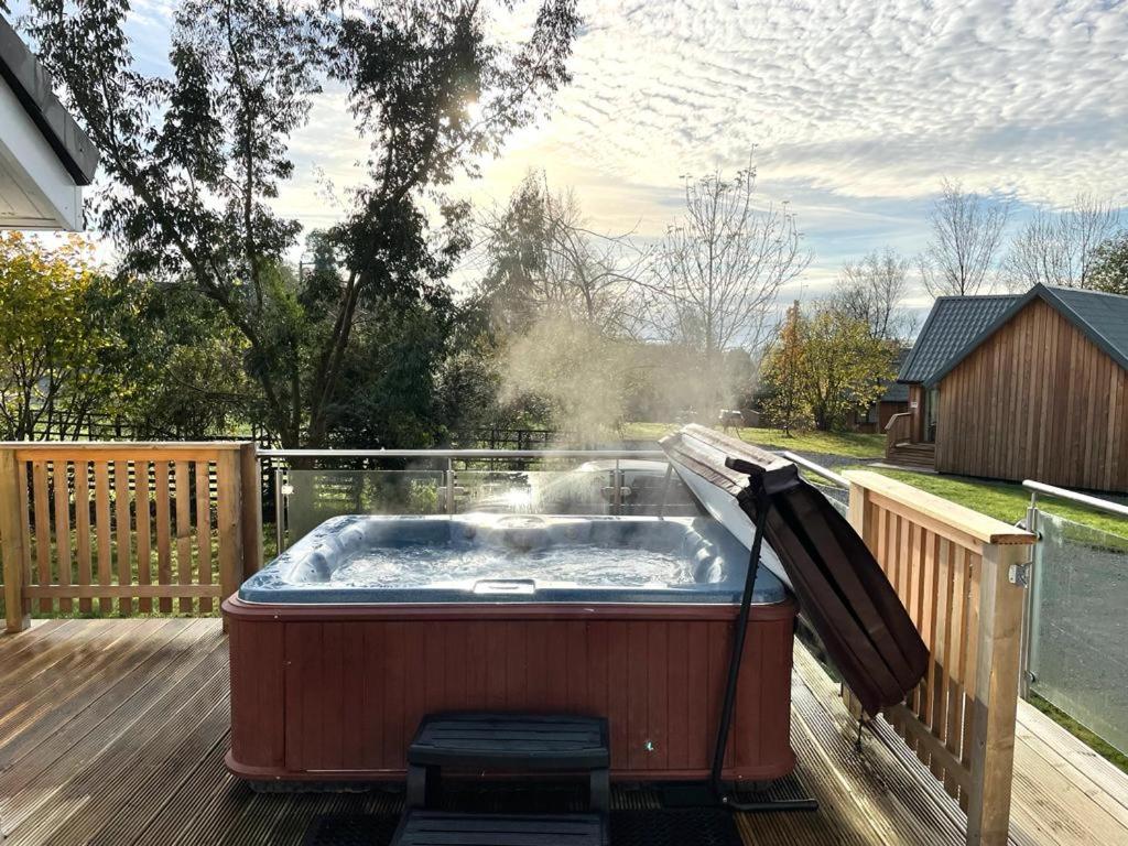 a hot tub on the deck of a house at Sparrowhawk Cottage with Hot Tub in Newton Stewart