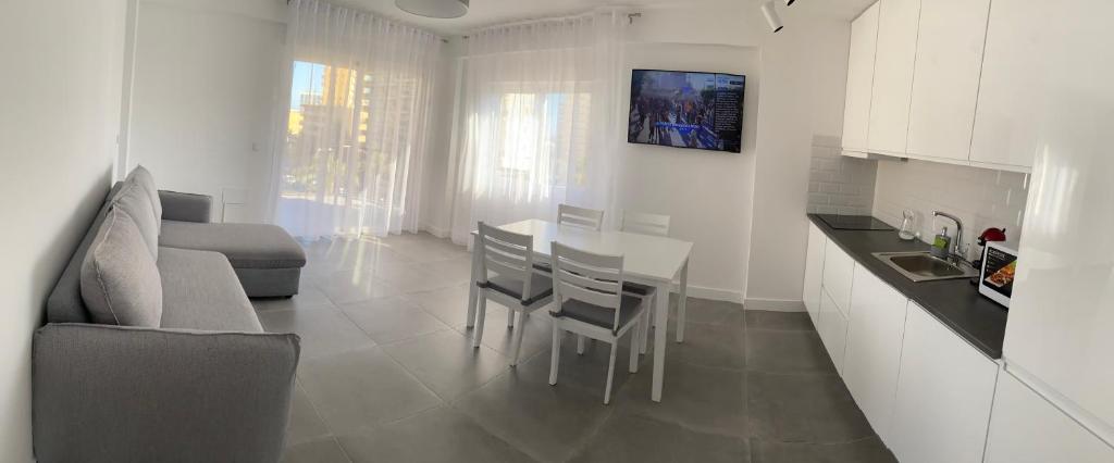 una cucina e un soggiorno con tavolo e divano di Apartamentos La Gaviota a Roquetas de Mar